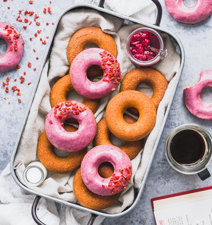 a tray full of donuts, some with raspberry glaze.