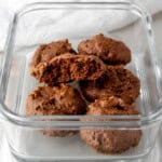 A meal prep container filled with homemade chocolate protein cookies.