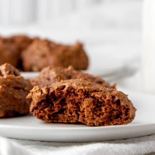 Close-up of soft, homemade chocolate protein cookies on a white plate.