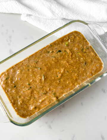 protein zucchini bread batter in glass loaf pan before going into the oven.