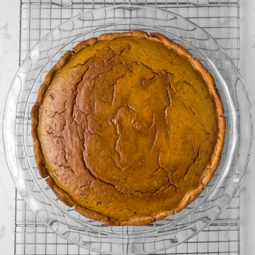 high protein pumpkin pie fresh out of the oven in a glass dish on a cooling rack.