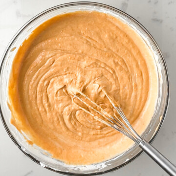 cream cheese, eggs, Greek yogurt, and pumpkin mixed well in a glass bowl.