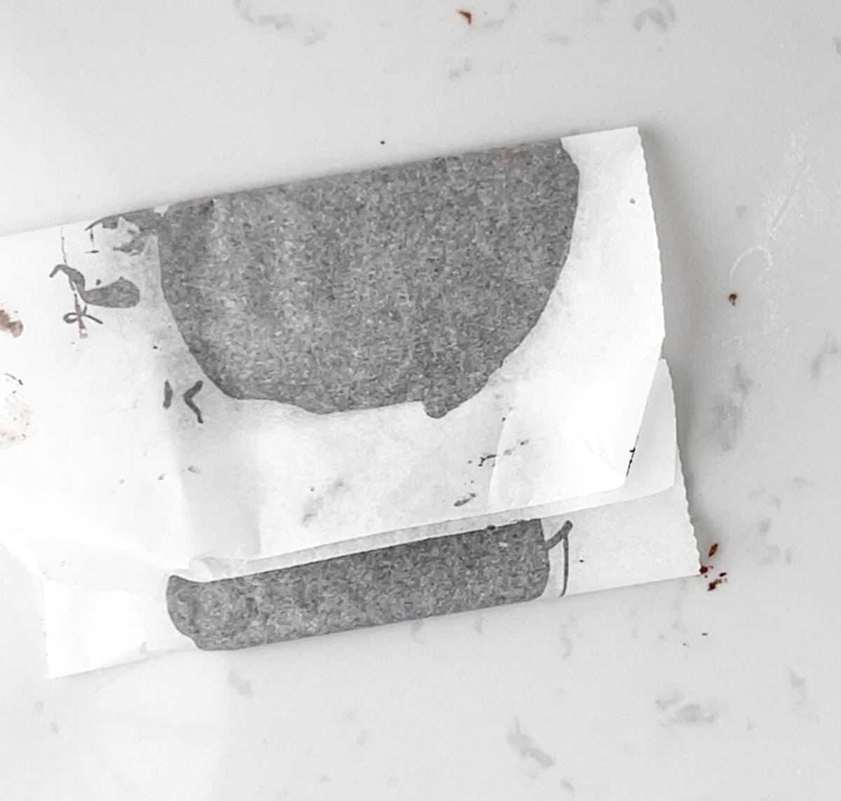 melted chocolate on parchment paper that is folded and ready for refrigeration.
