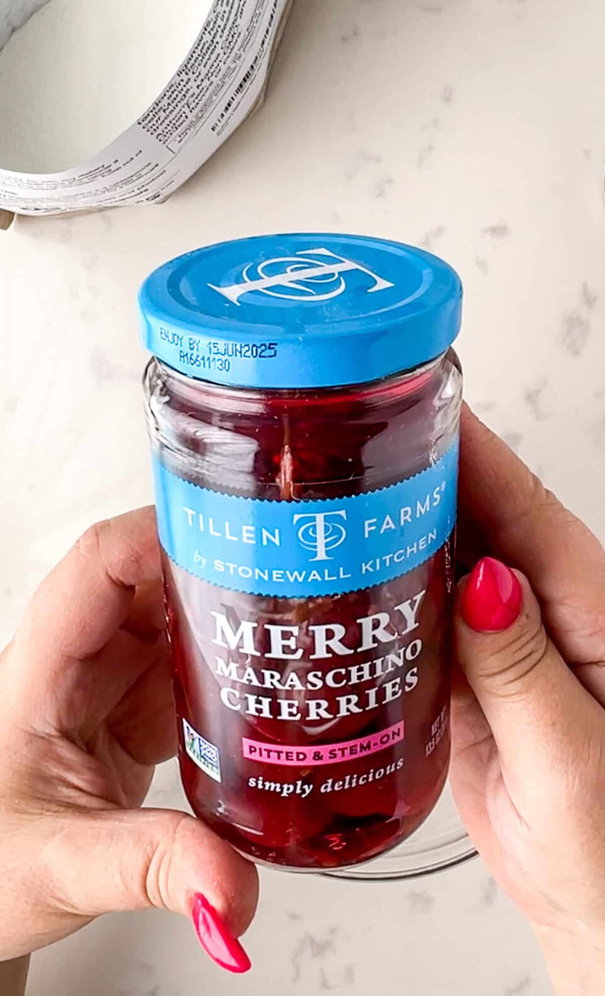 hand holding natural maraschino cherries next to a bag of marine collagen peptides.