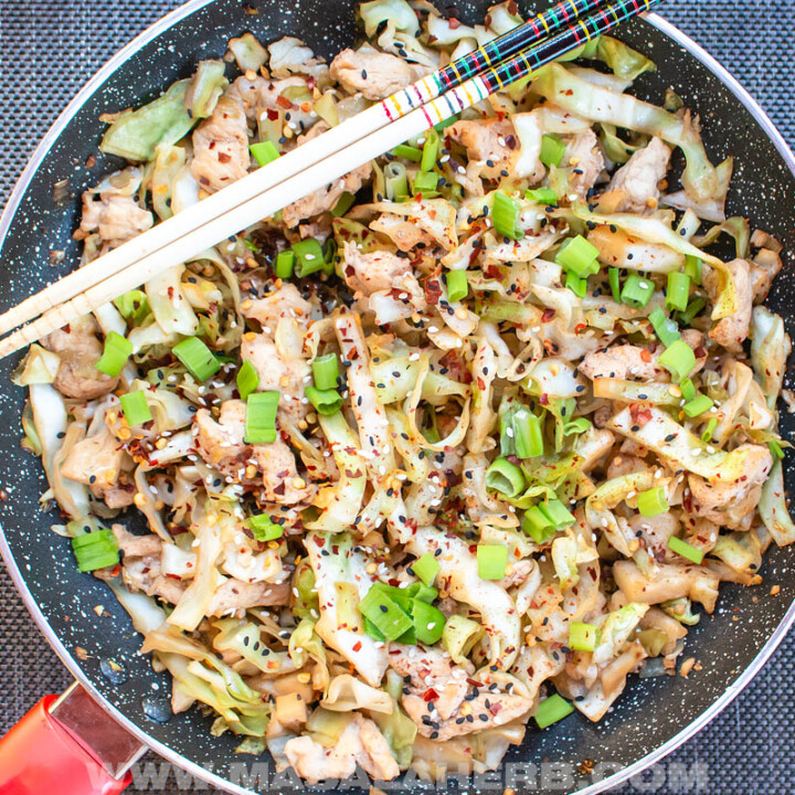 chicken cabbage stir fry in a bowl with chop sticks.