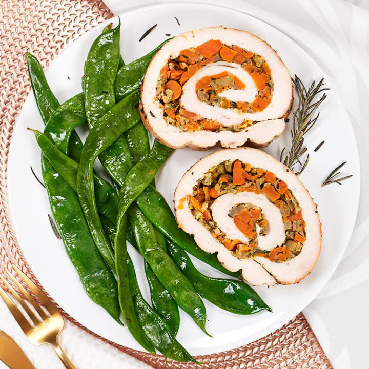 two slices of turkey roulade with snow peas.