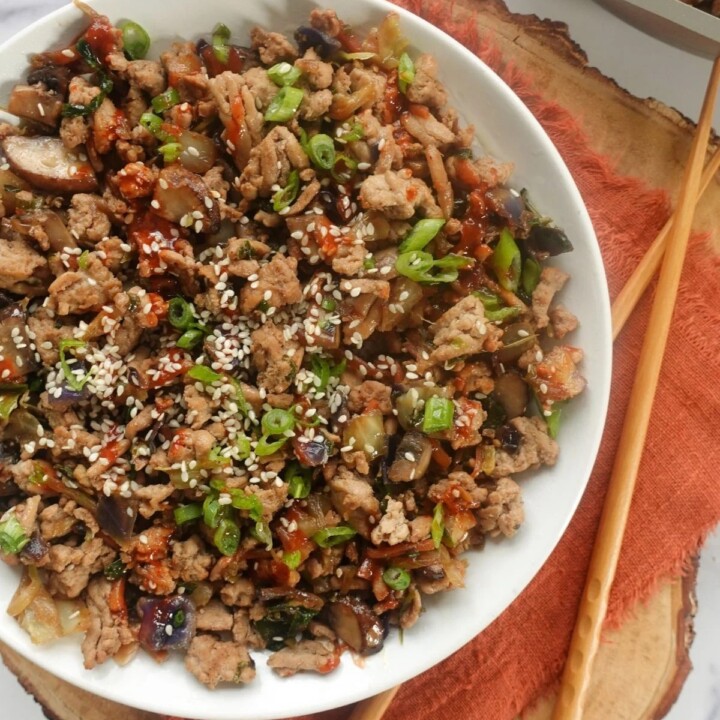 egg roll filling in a bowl next to chopsticks and a napkin.