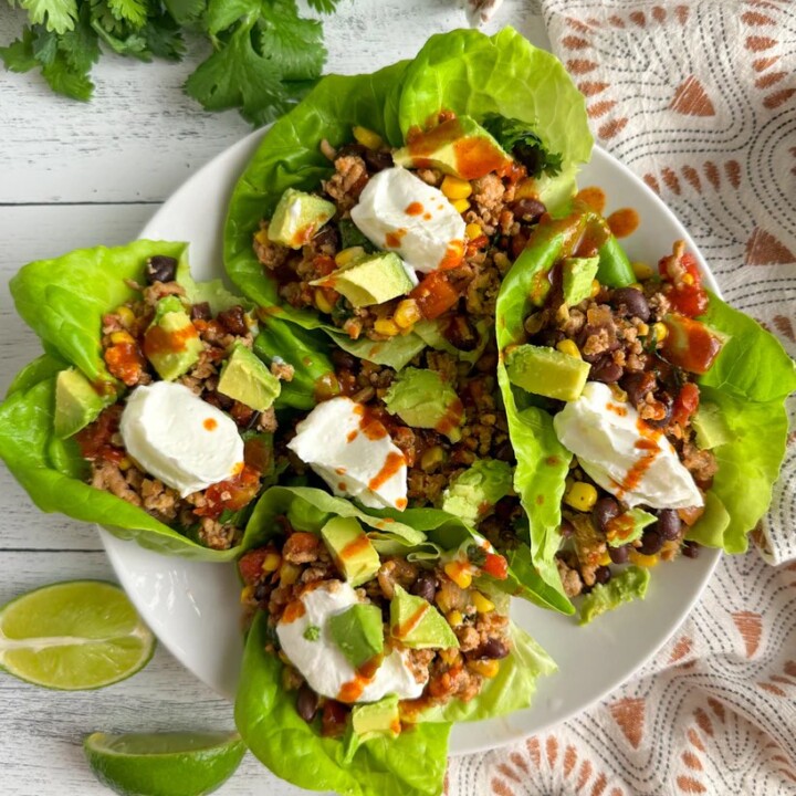 southwest chicken lettuce wraps on a plate with lime wedges.