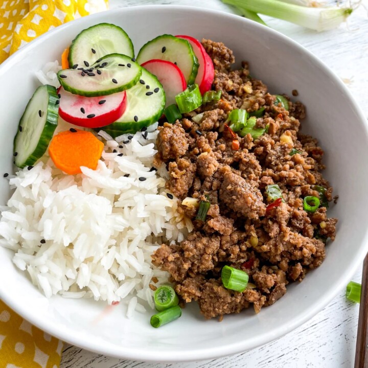 bowl of korean beef with rice and cucumber salad.