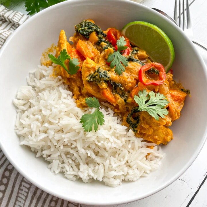 bowl with thai chicken coconut curry with white rice.