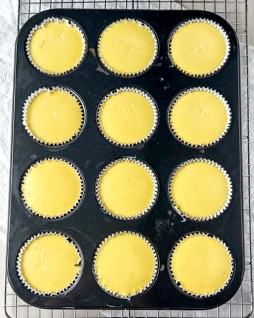 mini protein cheesecakes in a muffin tin after being baked in a water bath.