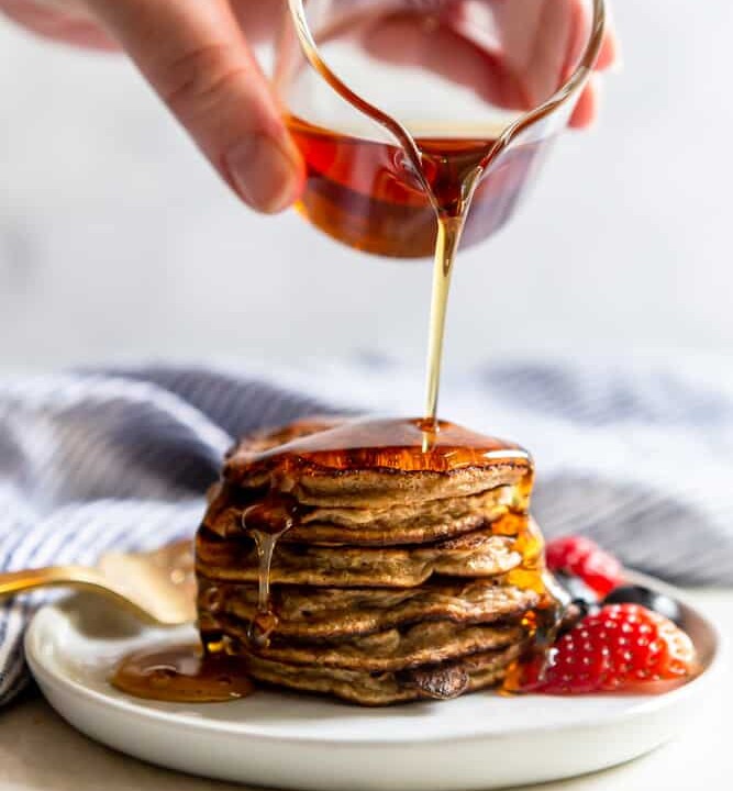 syrup being poured onto a stack of protein pancakes.