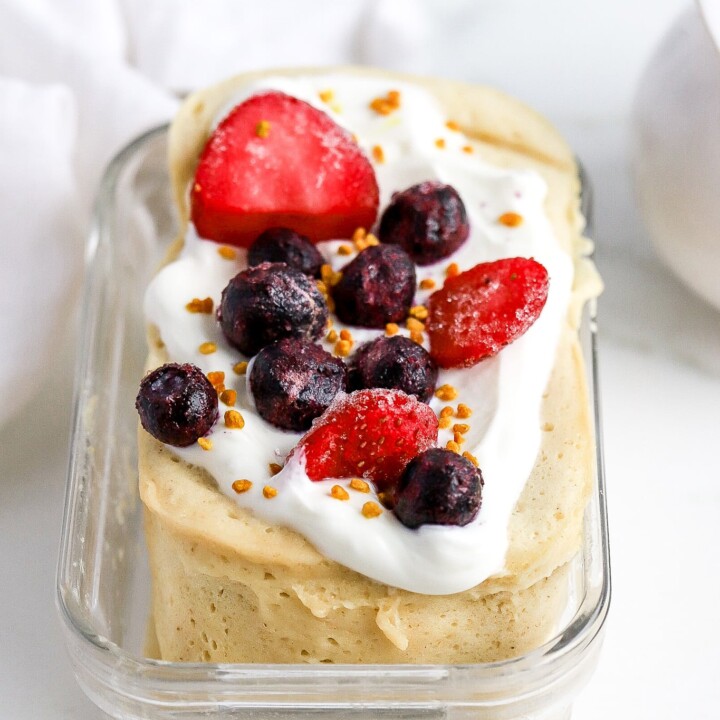 thick protein pancake in a meal prep container with berries.