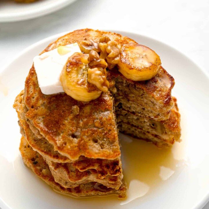 cut stack of protein pancakes with caramelized bananas.