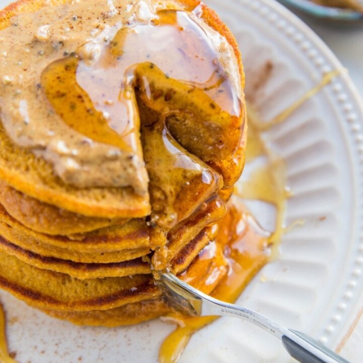cut stack of protein pancakes with syrup.