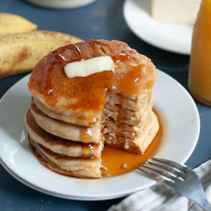cut stack of protein pancakes with butter and syrup.
