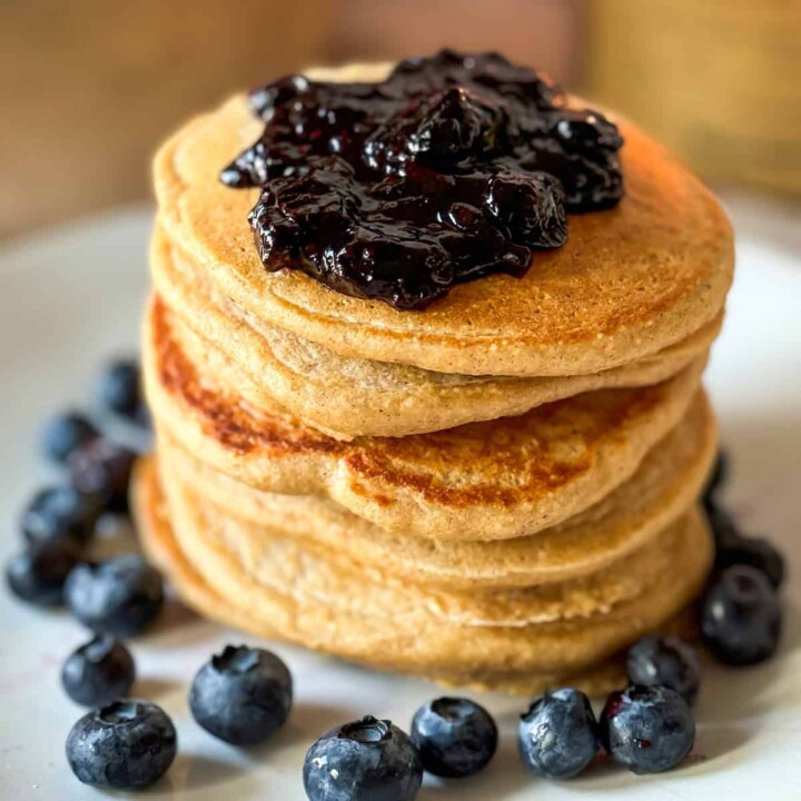 stack of protein pancakes topped with blueberry sauce.