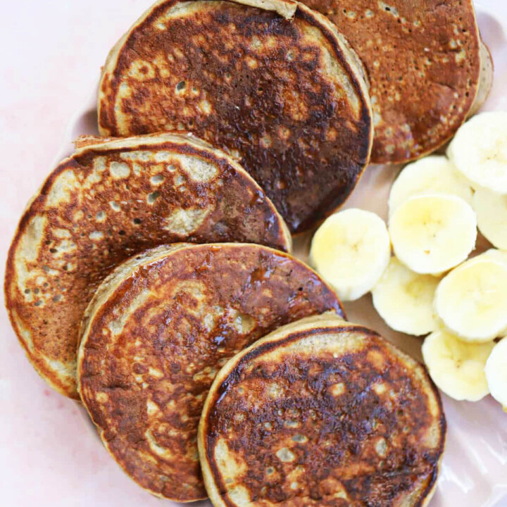 protein pancakes plated with sliced bananas.