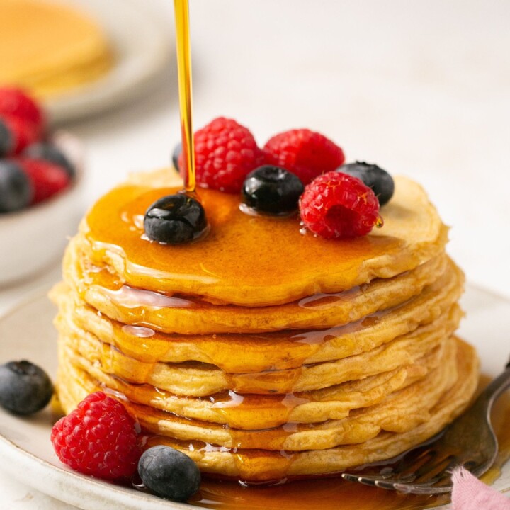 stack of protein pancakes topped with berries and syrup.