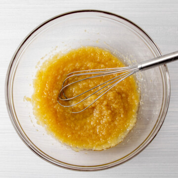 applesauce and coconut oil mixed in a bowl with a whisk.