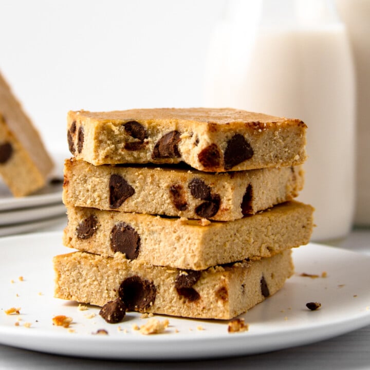 stack of chocolate chip protein blondies with milk in the background.