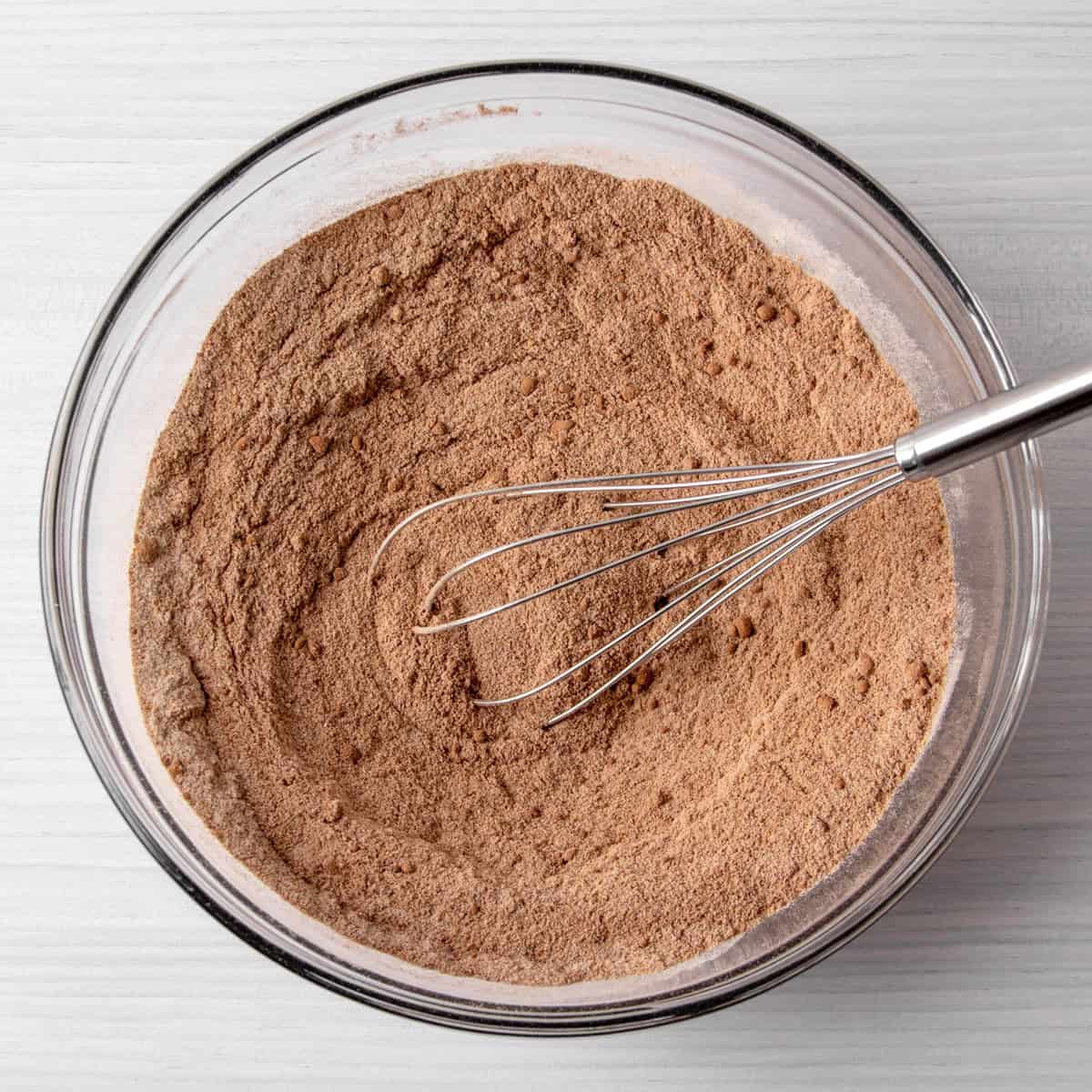 dry ingredients for collagen protein brownies mixed together in a bowl with a whisk.