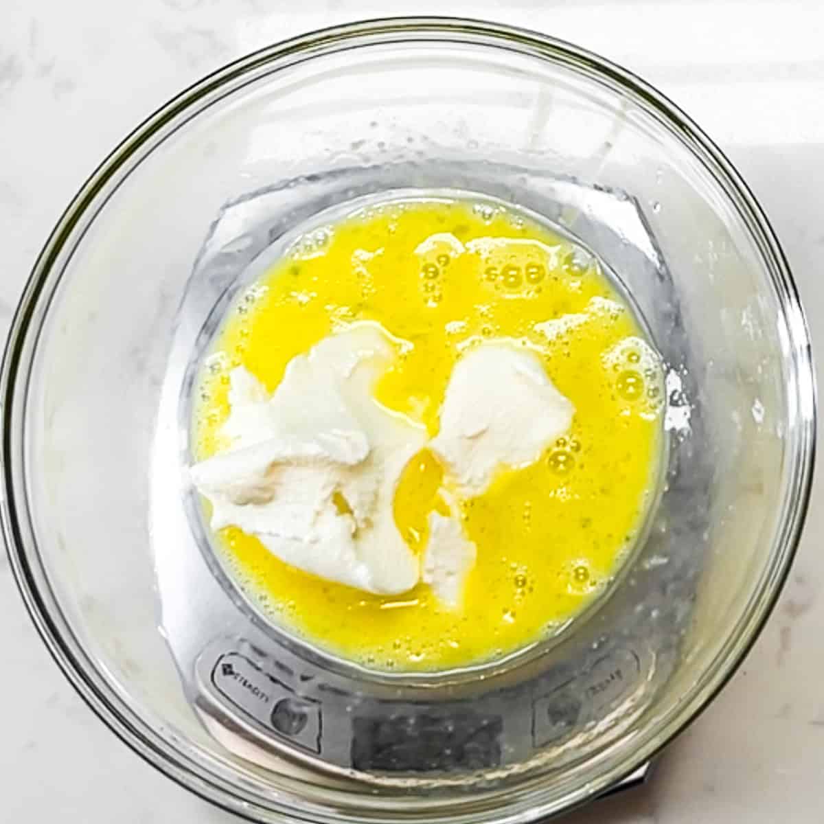 bowl with beaten egg and ricotta on a scale.
