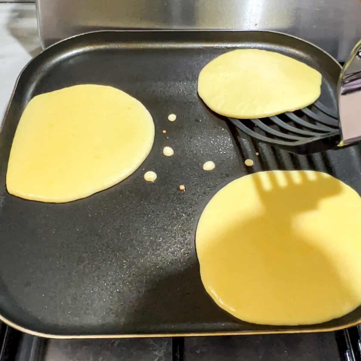 lemon ricotta protein pancake being flipped.