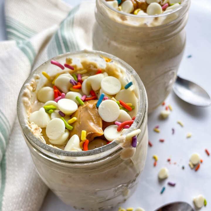 2 jars of overnight protein oats toped with sprinkles and white chocolate chips.