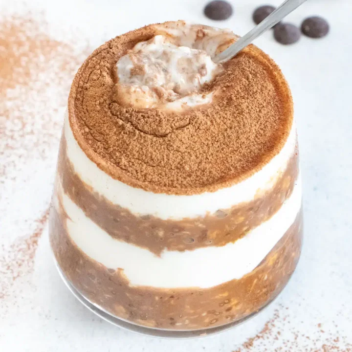 layered tiramisu overnight protein oats in glass serving dish.