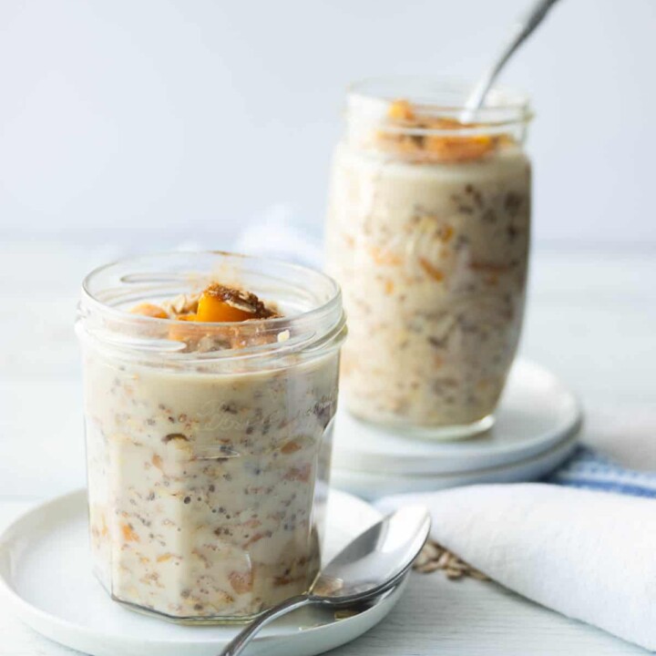 two servings of peach protein overnight oats in jars.