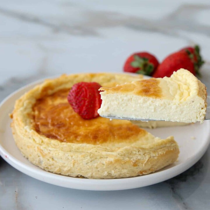 small cheesecake on a plate with strawberries.