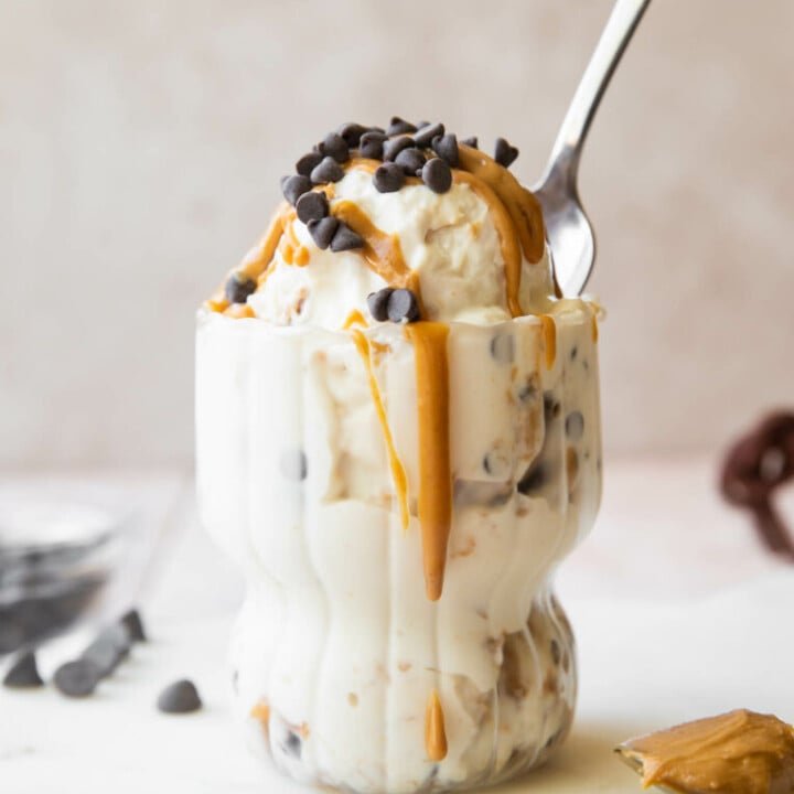 cottage cheese ice cream with chocolate chips and peanut butter in a glass with a spoon.