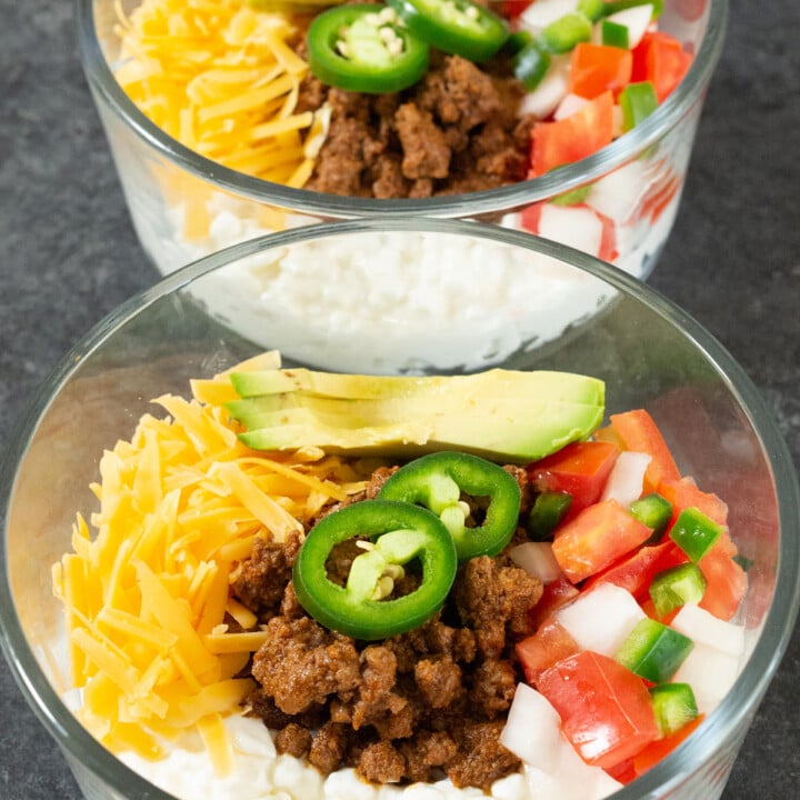bowls of cottage cheese with ground beef, cheddar, salsa, and avocado.