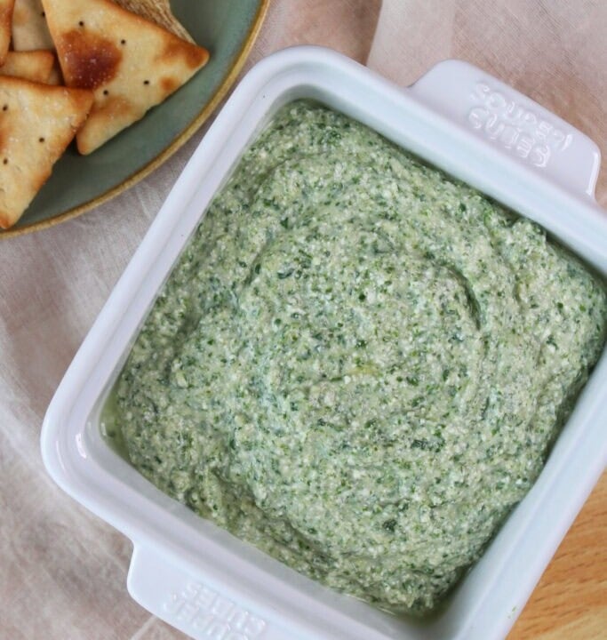 square ceramic dish of spinach artichoke cottage cheese dip.