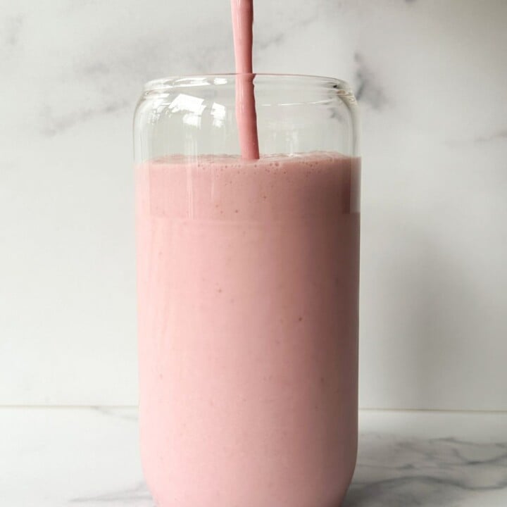 strawberry cottage cheese smoothie being poured into a glass.