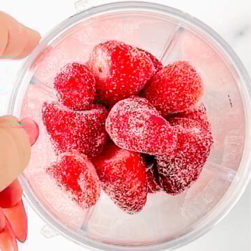 frozen strawberries in blender cup.