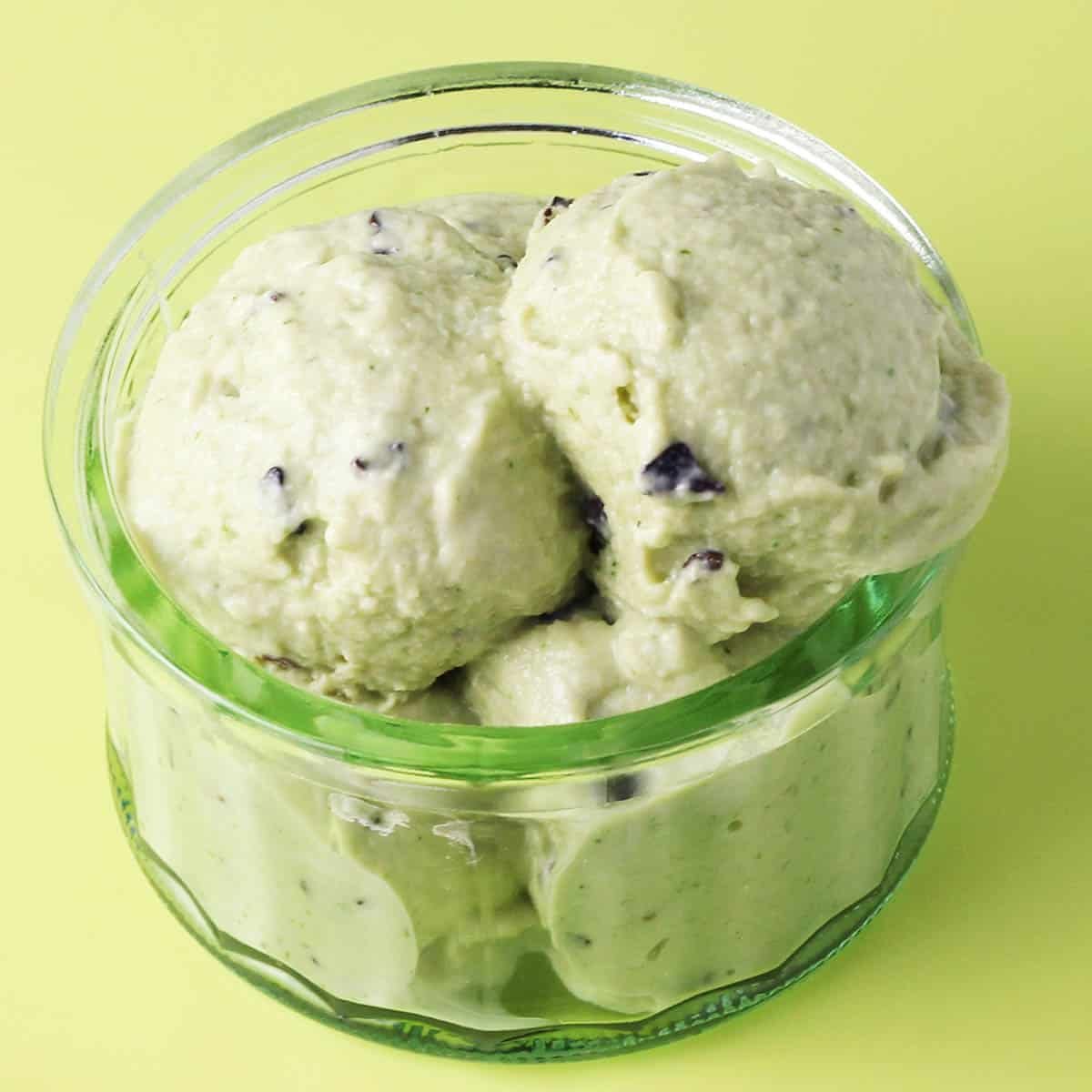 scoops of mint chip protein ice cream in a glass ice cream dish.