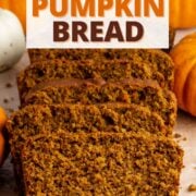 sliced loaf of high protein pumpkin bread on a cutting board surrounded by decorative mini pumpkins, with text overlay.