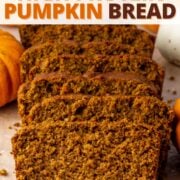 sliced loaf of high protein pumpkin bread on a cutting board surrounded by decorative mini pumpkins, with text overlay.
