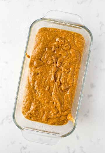 unbaked pumpkin protein bread in a glass loaf pan.
