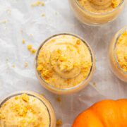 top view of 4 servings of pumpkin cheesecake mousse with a decorative mini pumpkin.