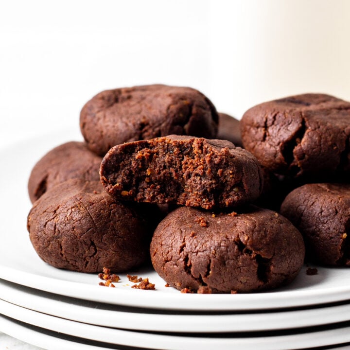 chewy chocolate protein cookies on a stack of plates.