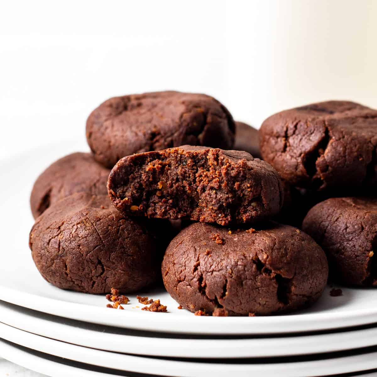 chewy chocolate protein cookies on a stack of plates.