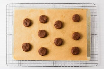 freshly baked chewy chocolate protein cookies on a wire cooling rack.