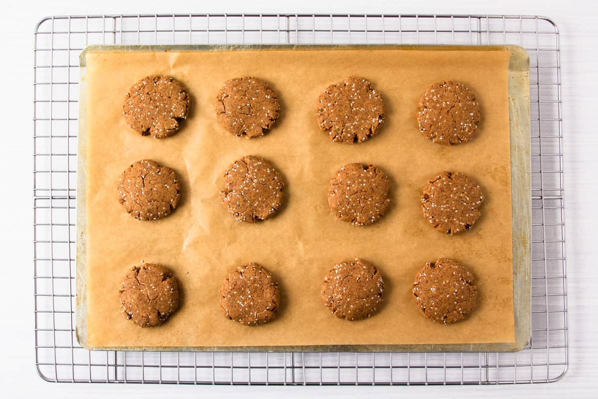 freshly baked chia almond protein cookies on a baking tray on a wire cooling rack.