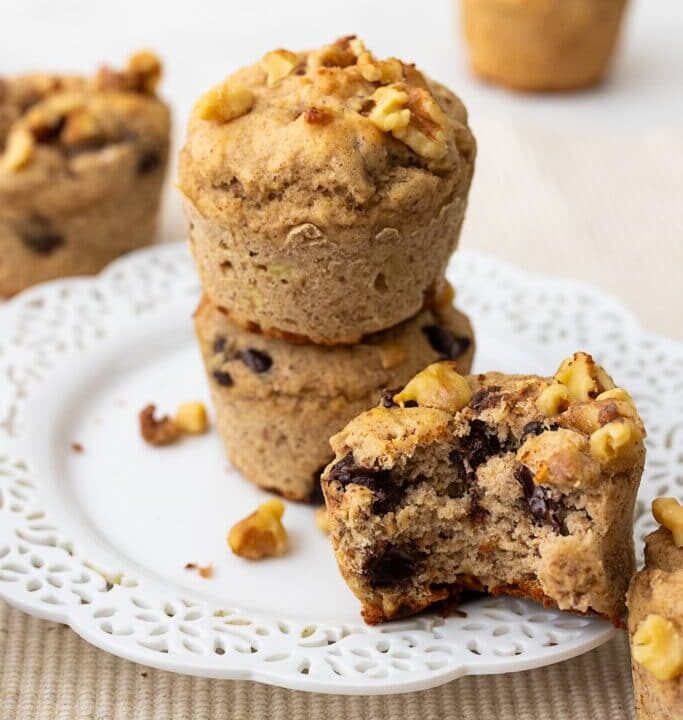 several protein muffins, one bitten, with chocolate chips and walnuts.