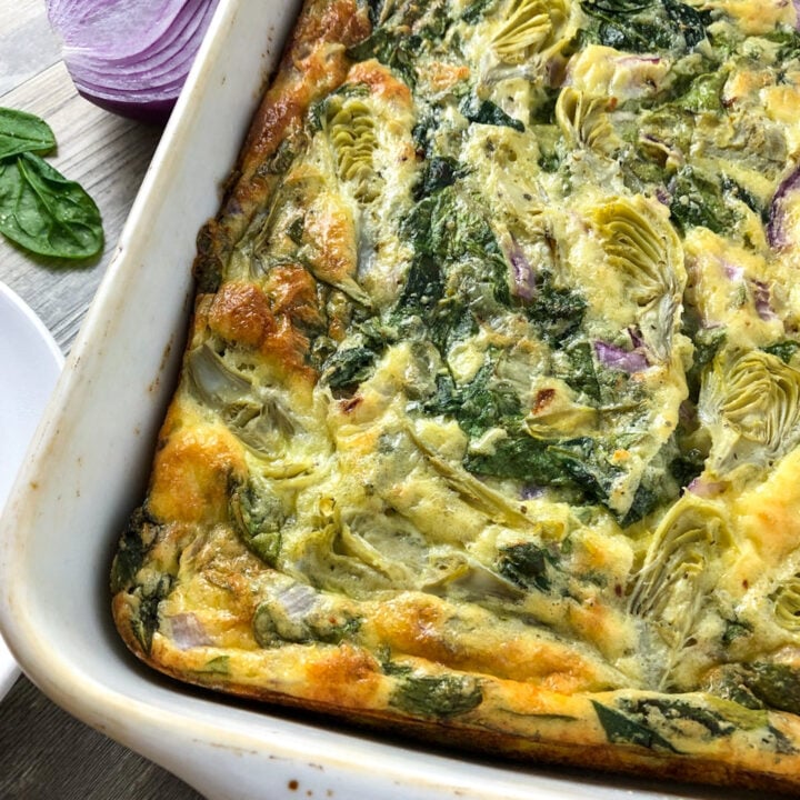 spinach artichoke egg casserole in a baking pan.