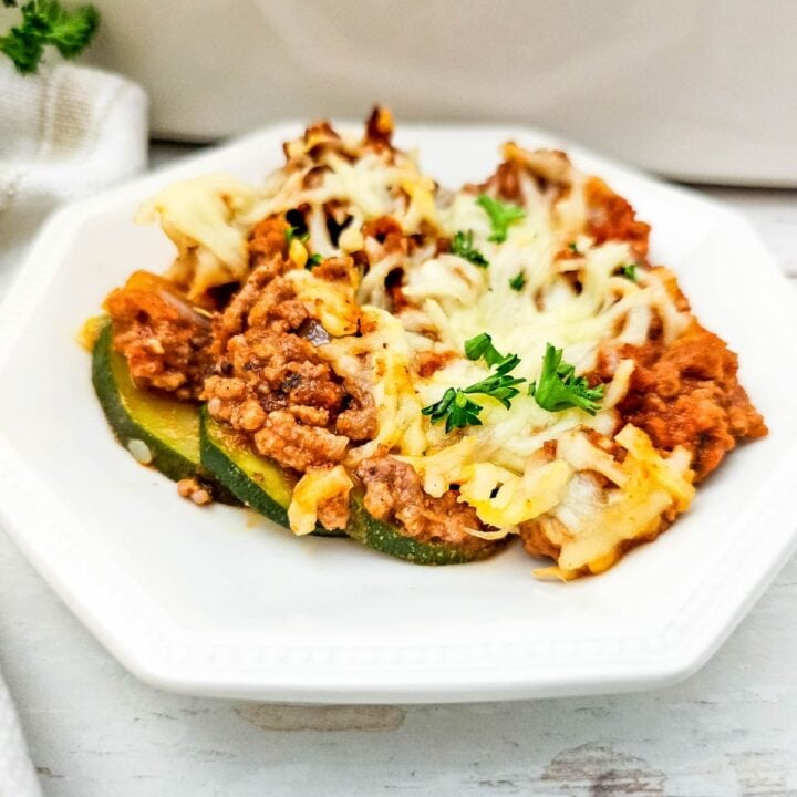 serving of ground beef and zucchini casserole with melted cheese and garnish.