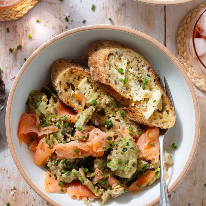 smoked salmon scrambled eggs with bread in a bowl.